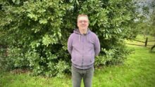 Un homme avec les bras dans le dos dans un jardin