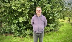 Un homme avec les bras dans le dos dans un jardin