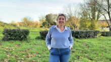 Une femme avec les mains dans les poches dans un jardin