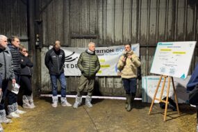 Des hommes rassemblés dans un bâtiment d'élevage laitier