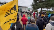 Un rassemblement de personne avec des drapeux de la Confédération Paysanne