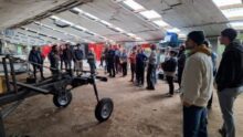 Des personnes dans un hangar autour de machines agricoles