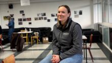 Une femme assise sur une table dans le foyer d'un établissement scolaire