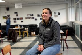 Une femme assise sur une table dans le foyer d'un établissement scolaire