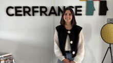 Une jeune femme pose devant un mur avec le logo Cerfrance
