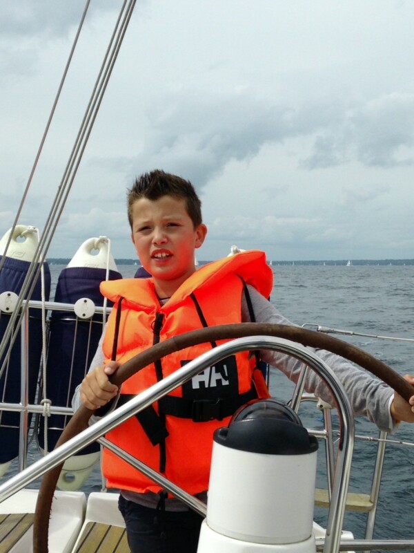 Le skipper Paul Loiseau, enfant, à la barre du bateau de ses parents
