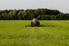 Un tracteur en train d'épandre du lisier dans un champ de culture