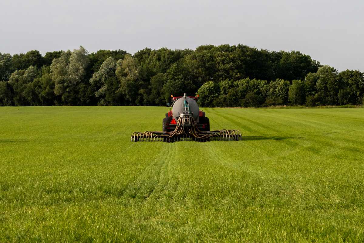 Un tracteur en train d'épandre du lisier dans un champ de culture - Illustration Déclaration  des flux d’azote avant le 31 janvier 2026