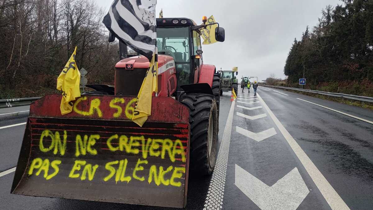 Un tracteur avec un godet et une inscription jaune 