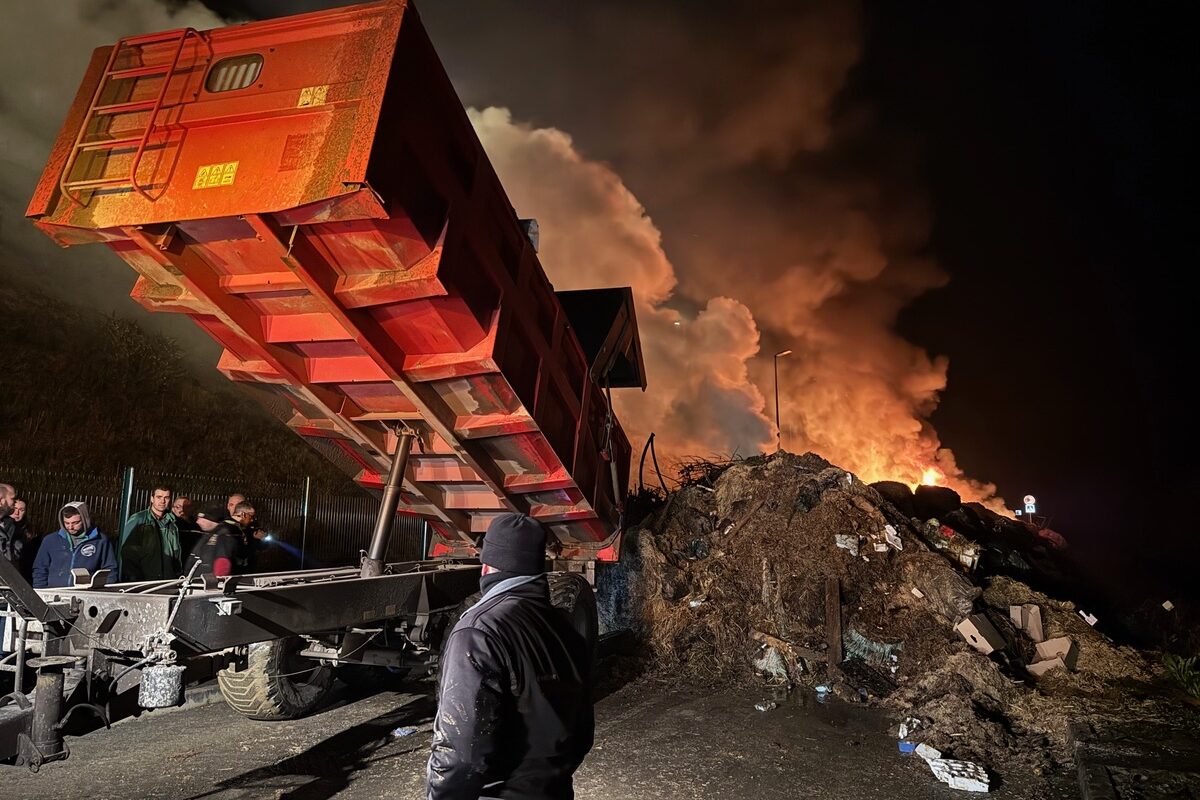 Une remorque en train de décharger des matériaux lors dun' manifestation agricole alors que le ciel est rempli de fumée - Illustration Efforts attendus sur l’origine France