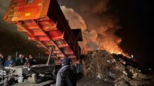 Une remorque en train de décharger des matériaux lors dun' manifestation agricole alors que le ciel est rempli de fumée
