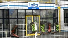 Des bottes en caoutchouc avec l'inscription 500 accrochées sur les grilles devant le bâtiment de l'entreprise laitière Laïta