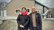 une femme et un homme devant un bâtiment de poules pondeuses