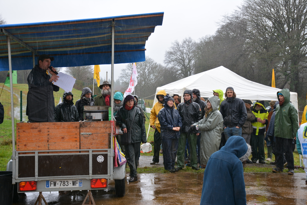Des manifestants écoutent, sous la pluie, une personne avec un micro installée sur une remorque couverte - Illustration La Confédération paysanne appelle à la résistance