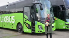 Une femme devant un bus vert
