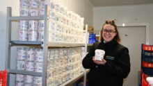 femme tenant du skyr devant une étagère