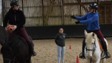 Deux jeunes cavaliers à cheval pratiquant le Horse Ball sous les yeux d'une monitrice.