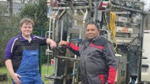 Deux hommes devant une cage de parage pour bovins