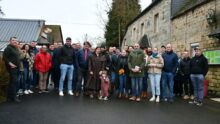 Des personnes devant des maisons de ferme