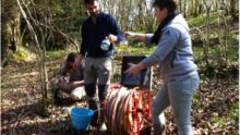 Trois personnes en train d'effectuer des analyses dans un bois
