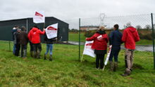 Des jeunes agriculteurs avec des drapeaux devant la station d'épuration