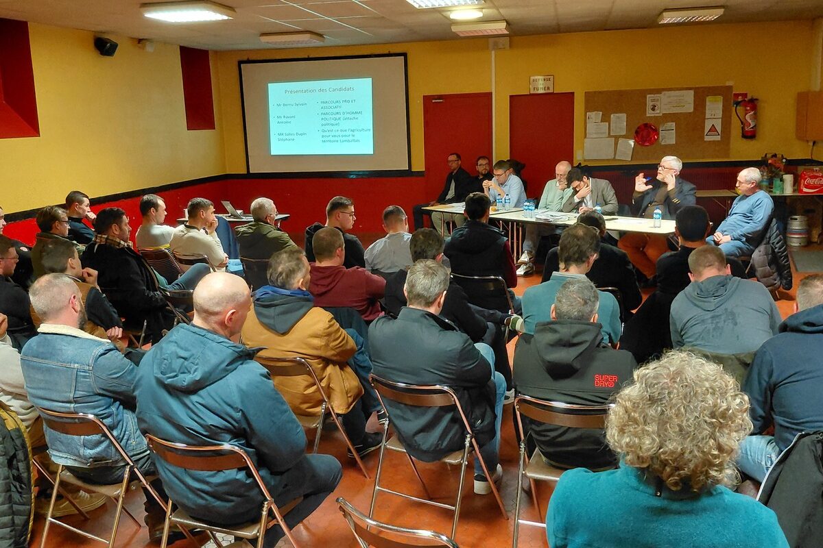 Une réunion rassemblant des gens face à des personnes assises derrière une table - Illustration À Lamballe, une réunion inédite entre agriculteurs et candidats