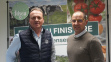 Deux hommes posent devant une affiche