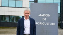 un homme devant des bâtiments de la maison de l'agriculture