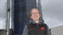 Une femme devant des silos de maïs dans son exploitation porcine