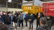 Des personnes devant des remorques agricoles