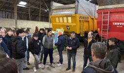 Des personnes devant des remorques agricoles