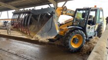 Un chariot télescopique avec un grappin dans un bâtiment