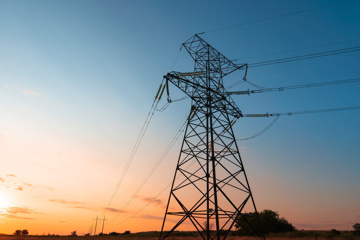 Un pilone électrique à la nuit tombante - Illustration Points de vigilance pour le renouvellement des contrats d’électricité