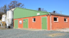 Vue extérieur d'un bâtiment d'élevage porcin avec des silos sur le côté