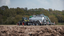 Un tracteur et une tonne à lisier au travail dans un champ