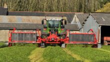 Un tracteur équipé d'un groupe de fauche coupe de l'herbe dans une prairie