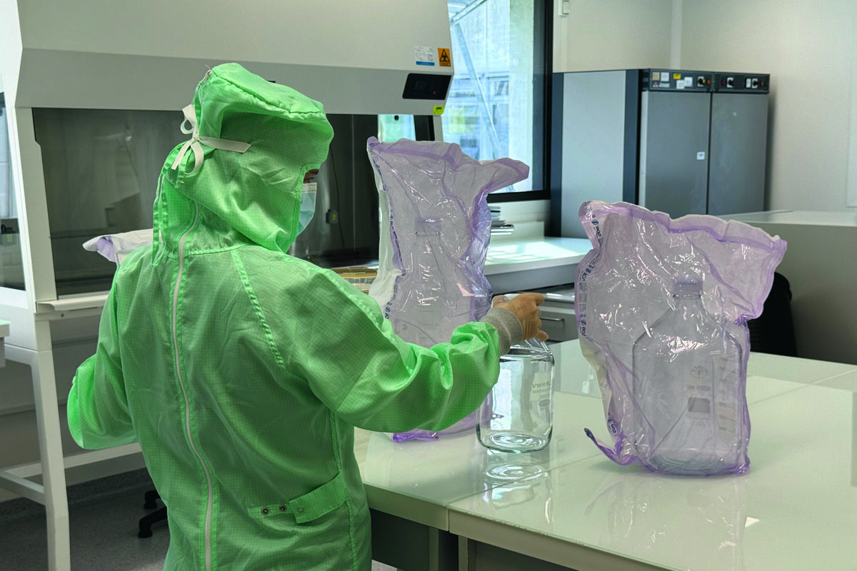 Un technicien avec une combinaison dans un laboratoire - Illustration La solution sur-mesure des  élevages
