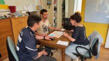 Deux hommes et une femme en réunion autour d'une table