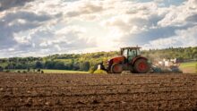 Un tracteur en train de labourer dans un champ au printemps