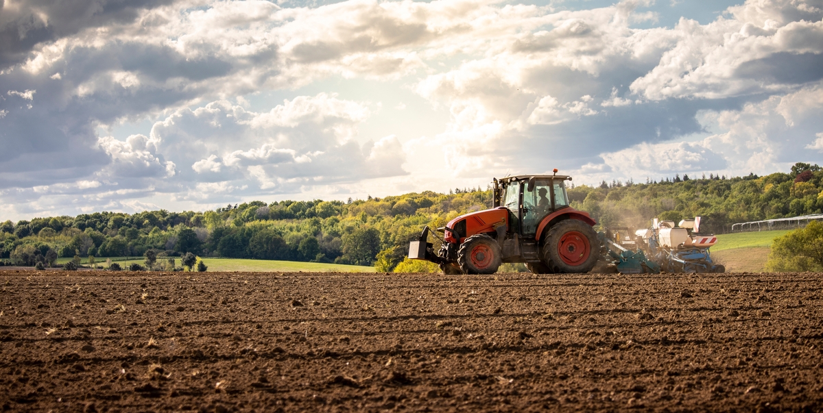 Un tracteur en train de labourer dans un champ au printemps - Illustration Tracteurs : rester vigilant pour garantir  la sécurité au travail 