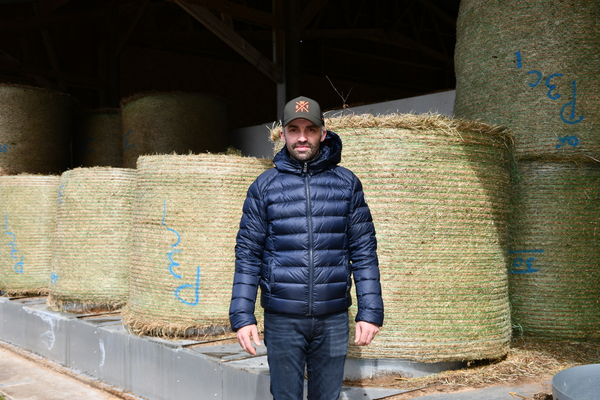 un éleveur devant des bottes de foin en round - Illustration Le pari de l’autonomie énergétique