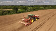 Vue aérienne d'un tracteur en train de semer du maïs dans un champ
