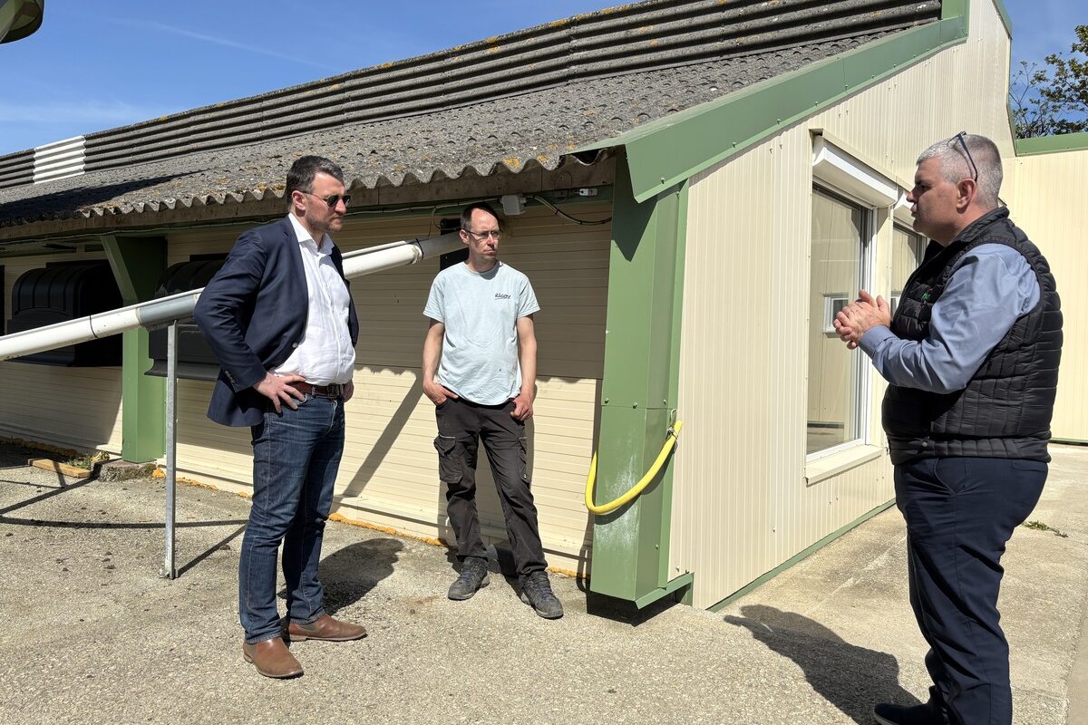 Des personnes devant un bâtiment d'élevage de volailles - Illustration La Région aide les investissements