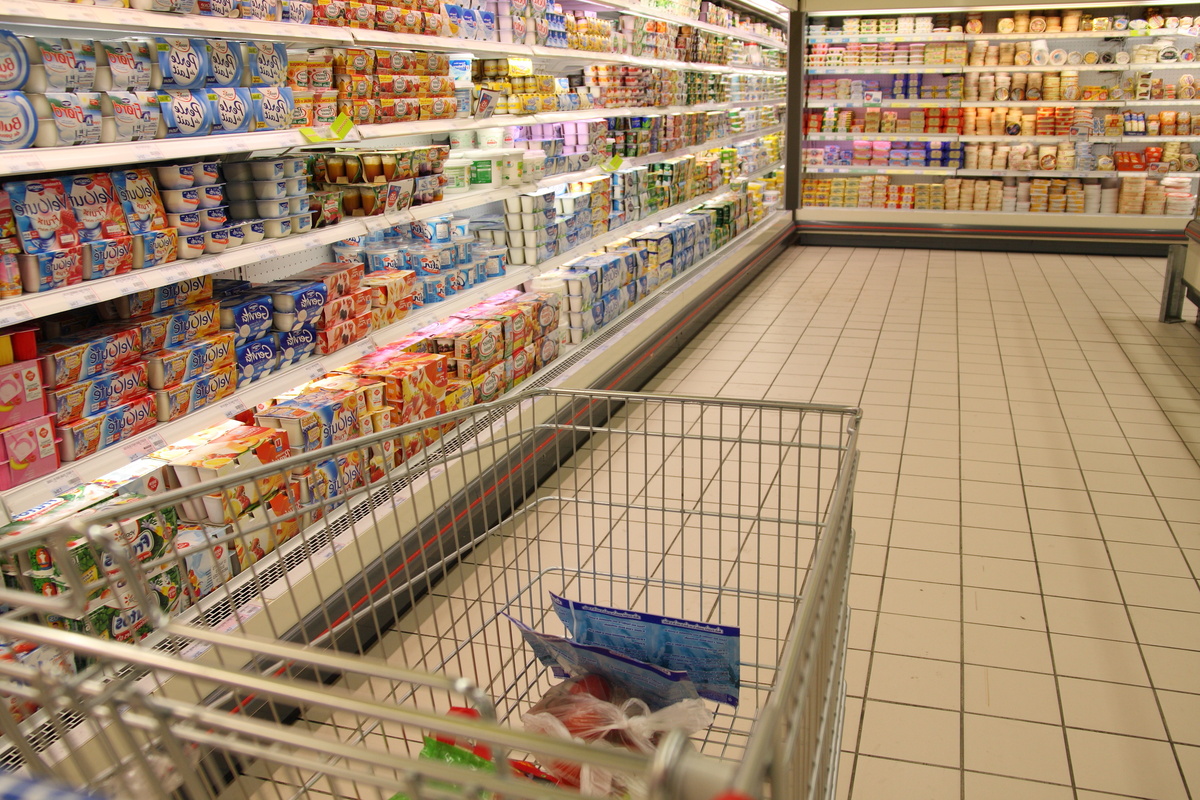 Un caddie dans une allée de supermarché au rayon yaourt - Illustration Annie Genevard repousse Égalim 4