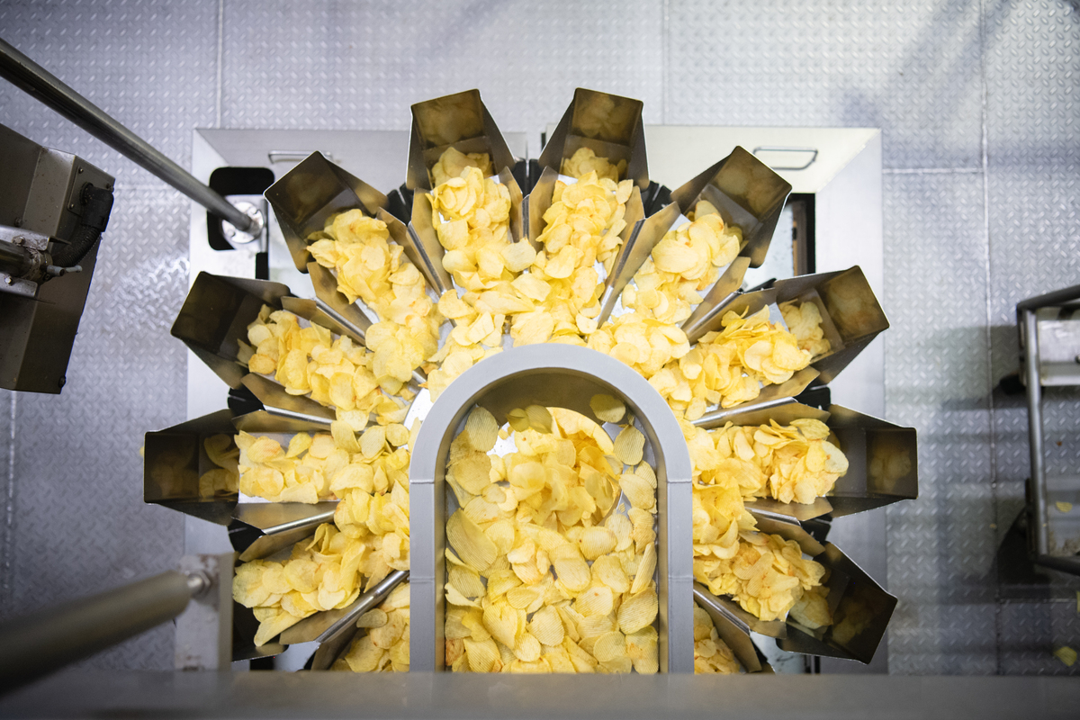 Vue du dessus d'une chaîne de production de chips - Illustration La nouvelle usine de chips tourne à plein régime