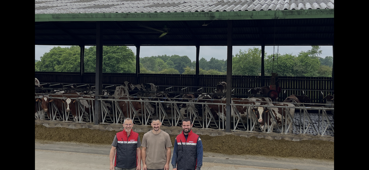 Trois hommes devant la table d'alimentation d'un bâtiment pour vaches slaitières - Illustration Le besoin de ventiler un bâtiment déjà ouvert