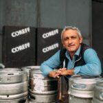 Un homme pose au milieu de fûts de bière Coreff