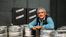 Un homme pose au milieu de fûts de bière Coreff